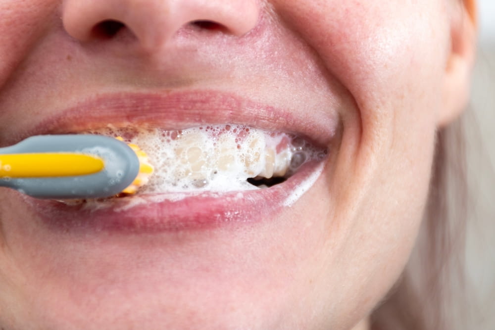 Une femme se brosse les dents lors de sa routine d'hygiène dentaire